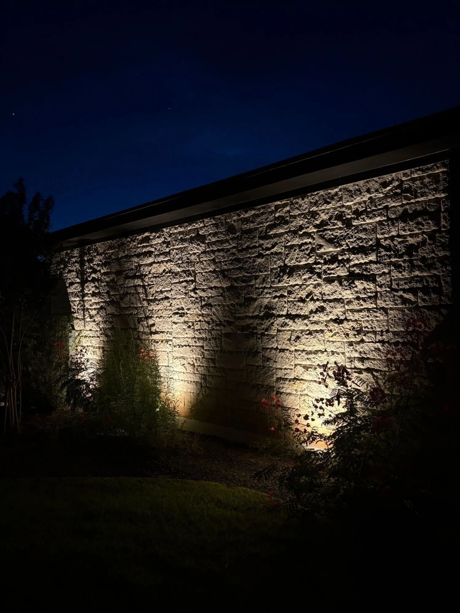 Rough-cut stone wall grazed with warm light to show its texture