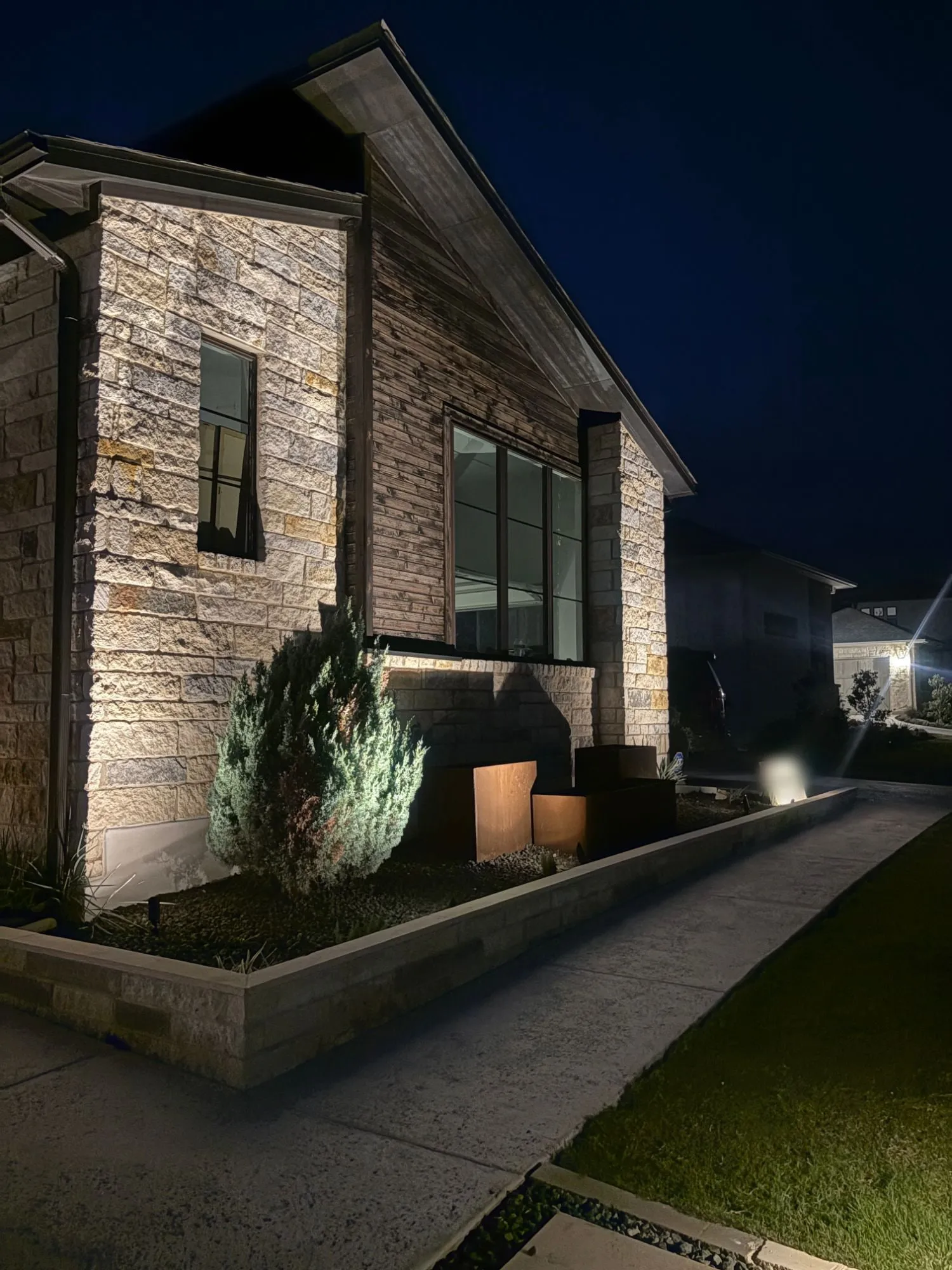 Stone and cedar gable with light grazing the stonework