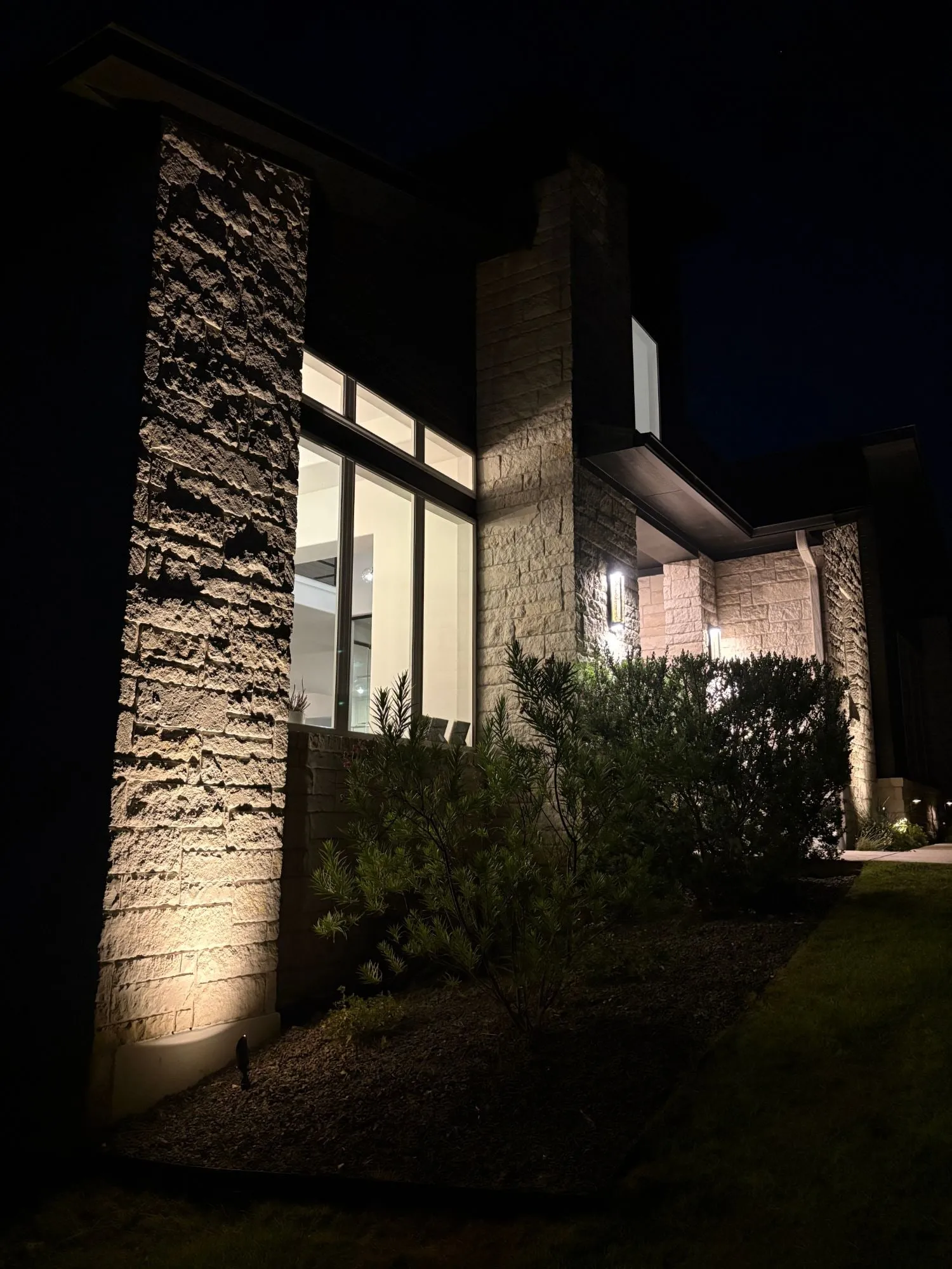 Tall stone column grazed from below beside floor-to-ceiling windows