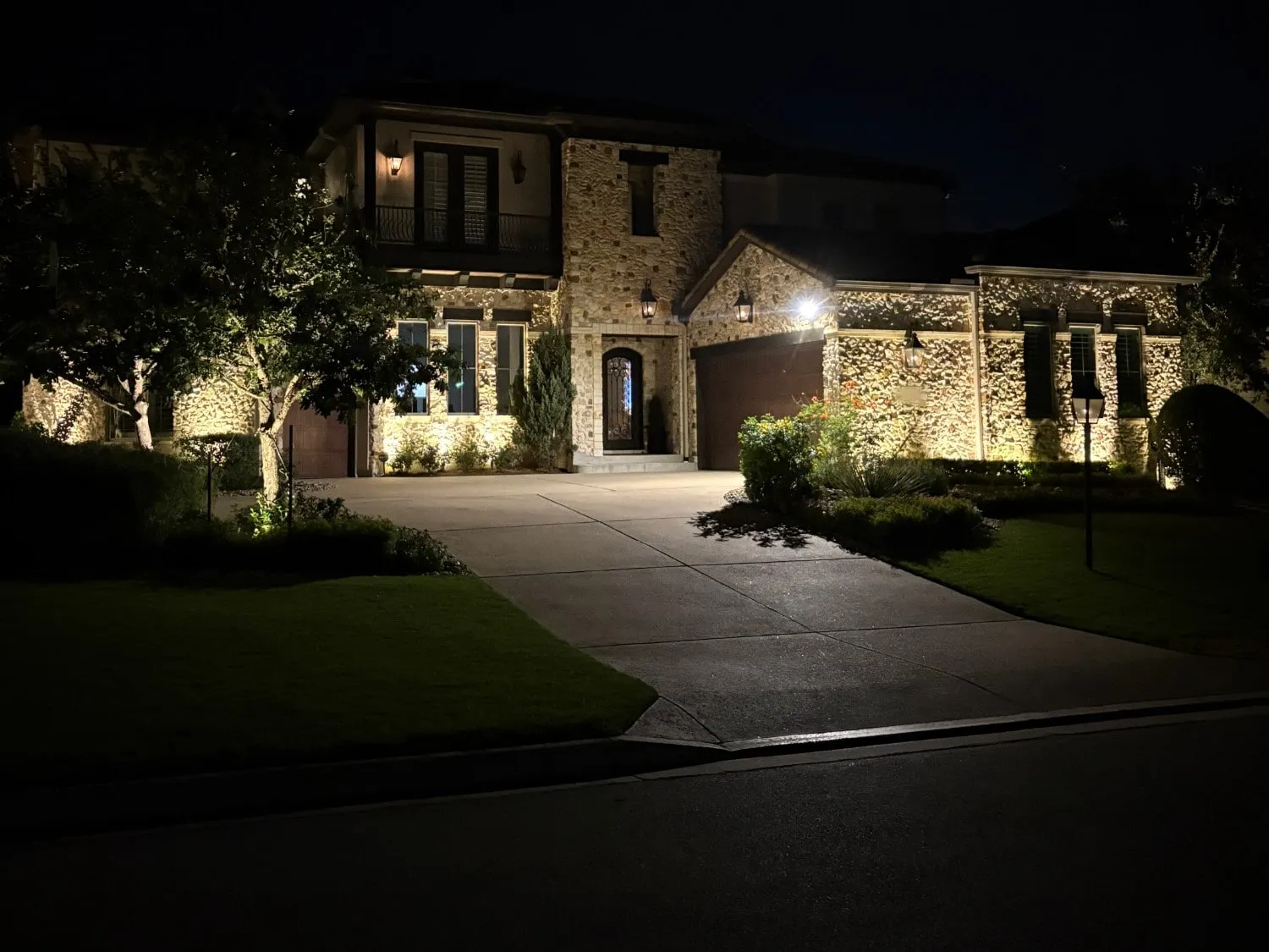 Stone facade and entry lit from the driveway